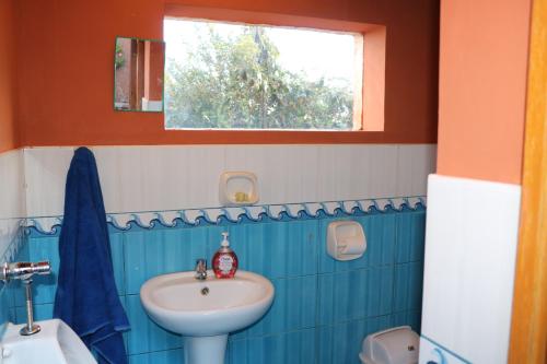 baño azul y blanco con lavabo y ventana en MOON NIGHT Amantani Lodge, en Ocosuyo