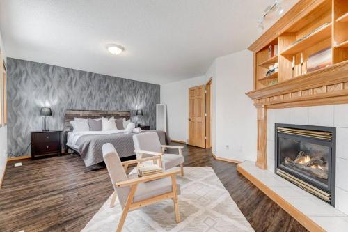 a bedroom with a bed and a fireplace at Coral Springs Lakefront Retreat in Calgary