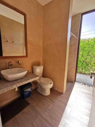 a bathroom with a toilet and a sink and a mirror at Casa Kay - 1 in Sisal