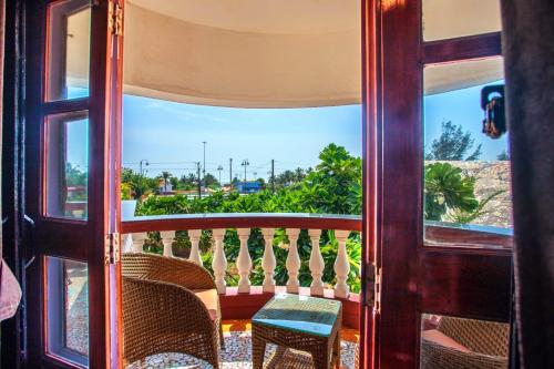 a door to a balcony with a view of the ocean at 'Golden Sunset' 3bhk beach villa in Benaulim