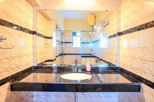 uma casa de banho com um lavatório e um espelho em 'Golden Sunset' 3bhk beach villa em Benaulim