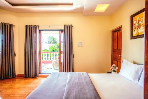 a bedroom with a bed and a large window at 'Golden Sunset' 3bhk beach villa in Benaulim