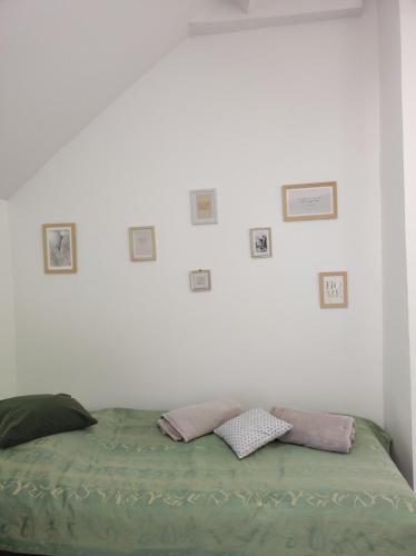 - un lit dans une chambre blanche avec des photos sur le mur dans l'établissement L'escale CDG Astérix Park d'exposition, à Louvres