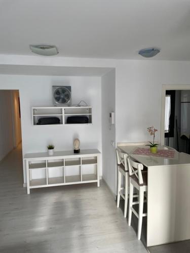 a white kitchen with a counter and a table at PURA VIDA in Arguineguín