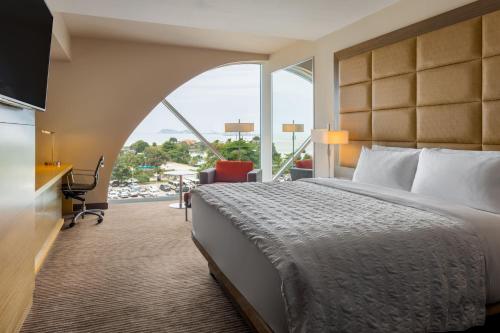 a hotel room with a bed and a large window at Le Meridien Panama in Panama City