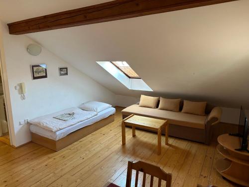 um quarto com uma cama e um sofá no sótão em Pension 325 em Tábor