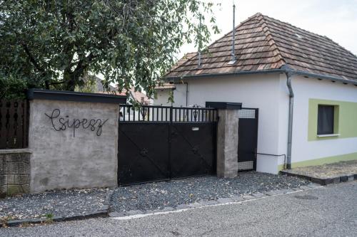 a black gate in front of a white house at Csipesz_Vendégház in Sümeg