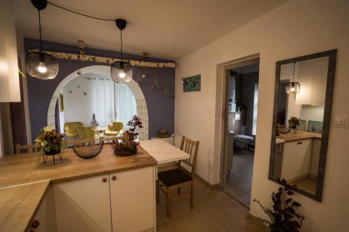 een keuken en een woonkamer met een tafel en een spiegel bij Csipesz_Vendégház in Sümeg