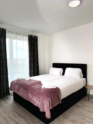 a bedroom with a large bed with a large window at Sky Apartments 503 in Pilsen
