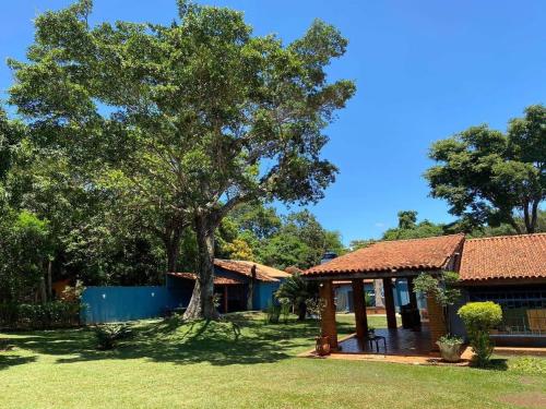 une maison avec un arbre dans la cour dans l'établissement Pousada Canto dos Passaros, à Chapada dos Guimarães