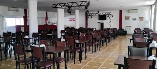 une salle remplie de tables et de chaises et d'une télévision dans l'établissement HOTEL 17 DE NOVIEMBRE, à Santa Teresita