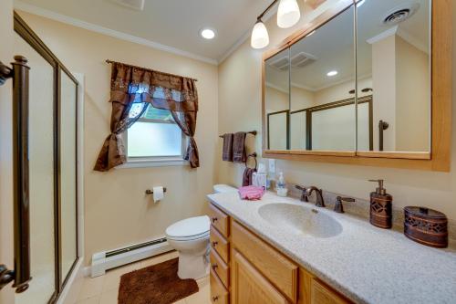 a bathroom with a sink and a toilet and a mirror at Cotys House Dog-Friendly Illinois Abode with Bar! in Streator