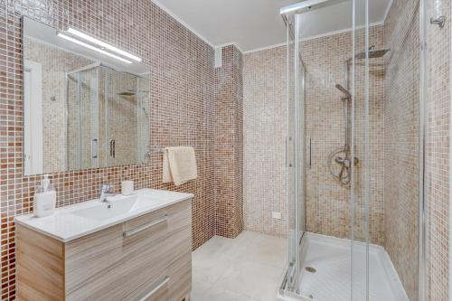 a bathroom with a shower and a sink and a mirror at Residencia El Duque - 1, VILLA MARIUS in Adeje