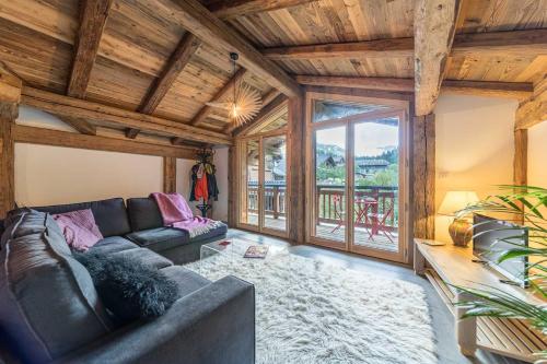 a living room with a couch and a large window at Le Refuge Au Pied d'Hauto in Montriond