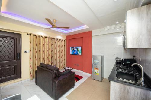 a kitchen with a refrigerator and a ceiling fan at Impeccable 1-Bedroom Furnished Apartment in Accra in Accra