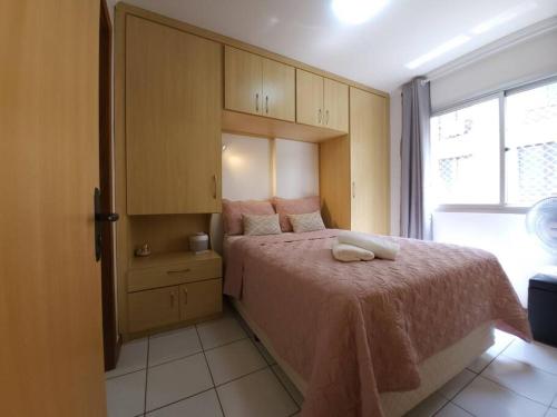 1 dormitorio con 1 cama con manta rosa y ventana en Sweet Home Sudoeste - Completo e aconchegante, en Brasilia
