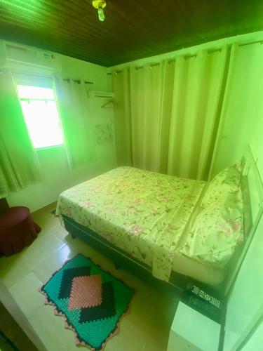 małe łóżko w pokoju z oknem w obiekcie Casa da Clau w mieście Cananéia