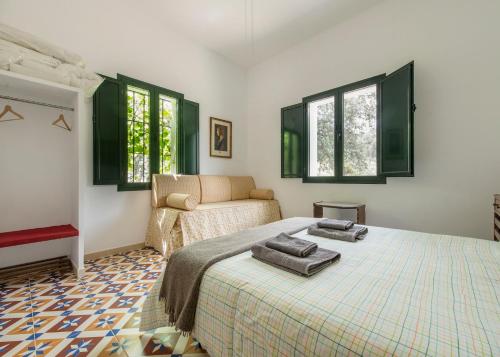 1 dormitorio con cama, sofá y ventanas en La Umbría de la Ribera, en El Pedroso