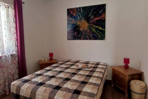 a bedroom with a checkered bed and a painting on the wall at Nazaré WSL Experience 2025 in Carrascal