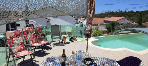 a patio with a table and chairs next to a swimming pool at Nazaré WSL Experience 2025 in Carrascal