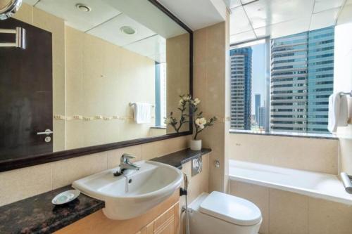 a bathroom with a sink and a toilet and a mirror at Breathtaking Skyscrapers View in Dubai