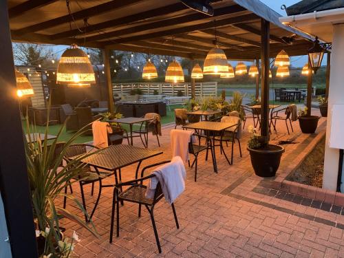 a patio with tables and chairs and pendant lights at The Old Red Lion Inn in Cambridge