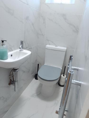 Surbiton的住宿－Surbiton Home with free parkings, Surbiton, Kingston upon Thames, Surrey, Greater London UK，白色的浴室设有卫生间和水槽。