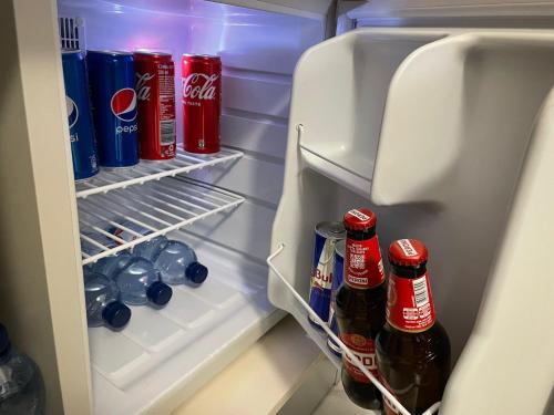 an open refrigerator filled with bottles and cans of soda at B&B Dei Vicari in Frattamaggiore