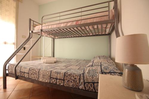 トッレ・サン・ジョヴァンニ・ウジェントにあるMare Di Pazzeのベッドルーム(二段ベッド1組、ランプ付)