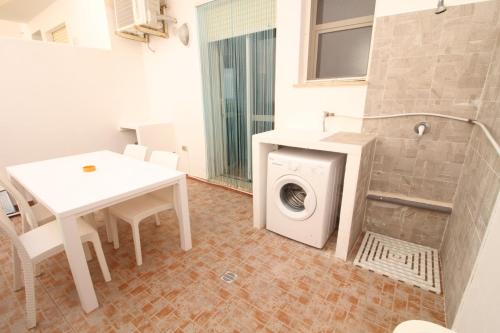 トッレ・サン・ジョヴァンニ・ウジェントにあるMare Di Pazzeのランドリールーム(洗濯機、テーブル付)