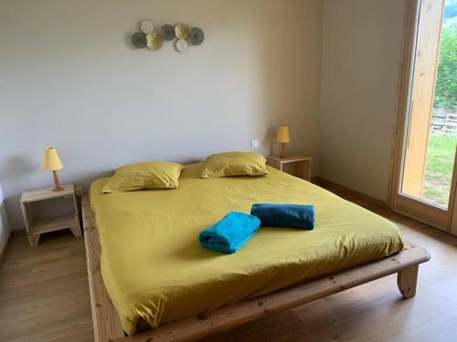 Una cama con dos almohadas azules encima. en Chalet le jardin de fées, en Saint-Gervais-les-Bains