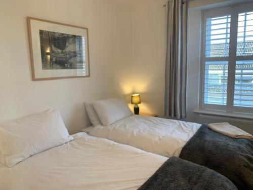 een slaapkamer met 2 bedden en een raam bij Newly refurbished Uplyme getaway in Uplyme