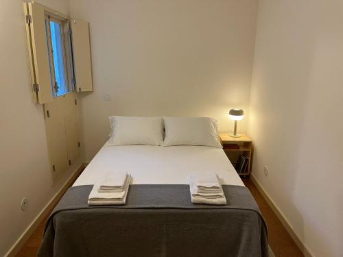 ポルトにあるPorto Siza Apartmentのベッドルーム1室(ベッド1台、タオル2枚付)