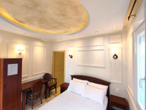 una camera con letto, scrivania e soffitto di Villa Miltiadis GreeceFiloxenia a Volos
