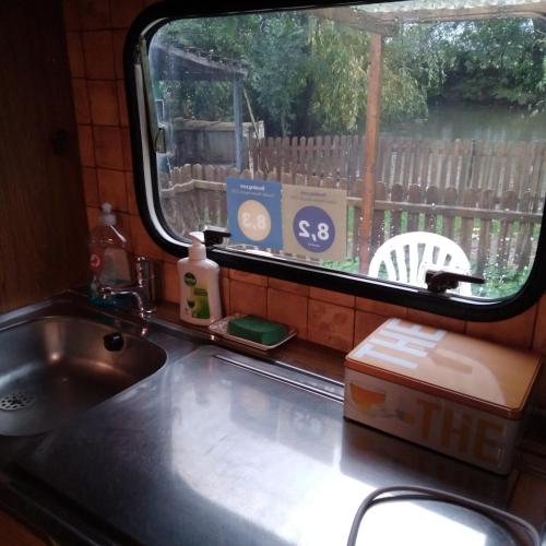 a kitchen counter with a sink and a window at ferme pedagogique des pennetieres in Montcorbon