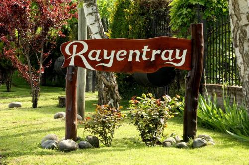 a sign for aryanasy sitting in the grass at Rayentray in El Bolsón