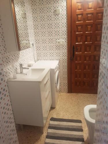 bagno con lavandino, servizi igienici e specchio di Apartamento los Delfines a Benissa