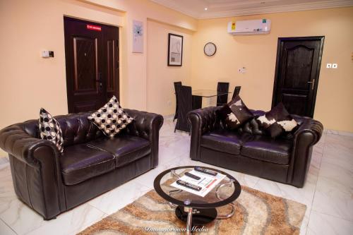 a living room with two leather couches and a table at Executive One Bedroom Furnished Apartment in Accra in Accra