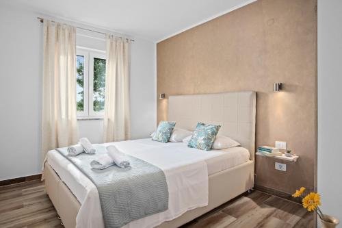 a bedroom with a large white bed with blue pillows at SPECIAL OFFER! NEW LUXURY APARTMENT with pool, fitness, outdoor bar&grill in Buje