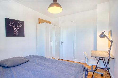 a bedroom with a bed and a desk and a lamp at La Pause Douce Cosy à Angoulême - Confort, Lumière et Espace in Angoulême