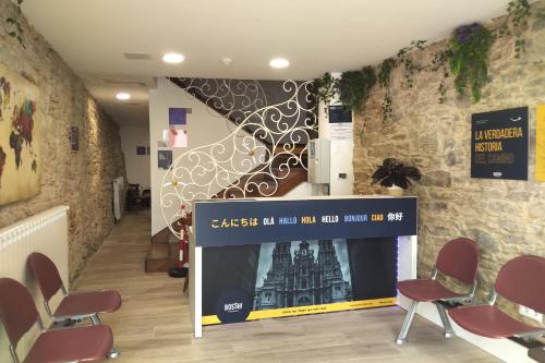 a waiting room with chairs and a wall with a staircase at Hostel SP 55 by Bossh! Hotels in Santiago de Compostela