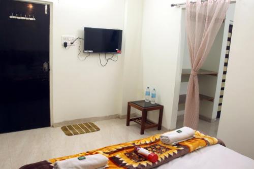 a room with a bed and a tv on the wall at Hotel Taj Bi Plaza in Aurangabad