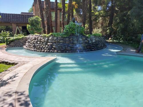 uma piscina com uma cascata num quintal em Hotel Villa el Descanso em Curicó