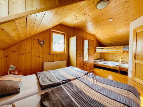 een slaapkamer met 2 bedden in een houten hut bij Ferienhaus Kärnten Stückler in Hochrindl