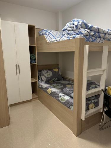 niewielka sypialnia z łóżkiem piętrowym i łóżkiem w obiekcie Privée Homestay w mieście Davao