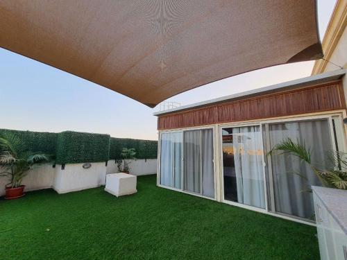 an empty patio with green grass on a house at Paradise Studios in Sheikh Zayed