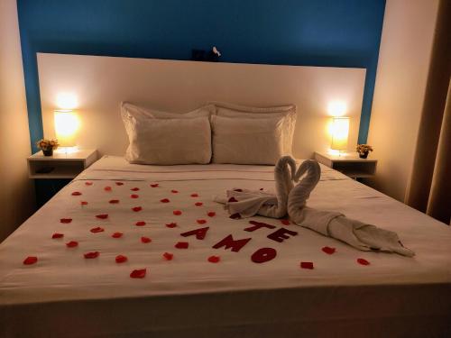 a bed with a bunch of red hearts on it at Pousada Marcos in Guarujá