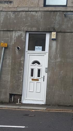 a white door on the side of a building at West Brae Inn in Paisley