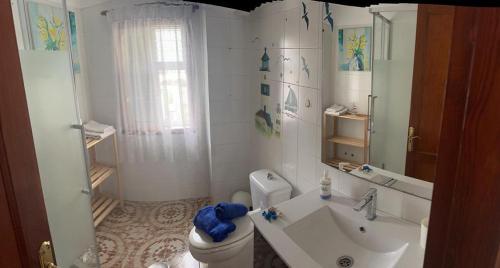 a white bathroom with a sink and a toilet at Casa Angelmar by Apartamentos Estrella del Norte in Puerto de Santiago