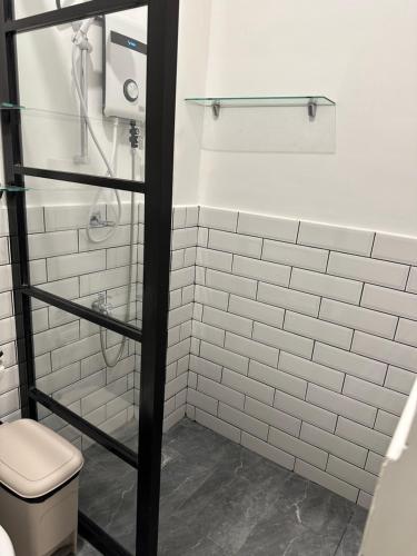 uma casa de banho em azulejos brancos com um WC e um chuveiro em Privée Homestay em Dávao